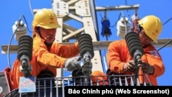 Công nhân của Tập đoàn Điện lực nhà nước EVN đang lắp ráp sửa chữa đường dây điện ở Việt Nam. Nghị định mới về quy chế mua bán điện trực tiếp sẽ loại bỏ sự độc quyền phân phối điện của EVN.