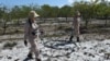 FILE - Members of a demining team look for unexploded ordnance in the Trieu Phong district of Quang Tri province, Vietnam, Jan. 6, 2020. 