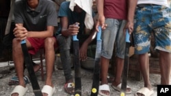 FILE - Community group members hold their machetes in Delmas district as they support the "Bwa Kale" movement, an initiative to fight gangs seeking to take control of their neighborhood in Port-au-Prince, Haiti, May 28, 2023. 