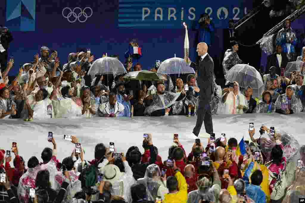 Zinedine Zidane rước đuốc trong lễ khai mạc Olympic Paris Mùa Hè 2024, hôm 26/7 (ảnh: AP Photo/Natacha Pisarenko)