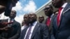 Smith Augustin, center, a member of the new transitional council, speaks to the press after the swearing in of the council in Port-au-Prince, Haiti, April 25, 2024. 