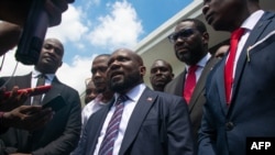 Smith Augustin, center, a member of the new transitional council, speaks to the press after the swearing in of the council in Port-au-Prince, Haiti, April 25, 2024. 