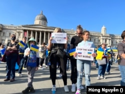 Gia đình người Nga này mang cờ Ukraine trong khi người mẹ cầm biểu ngữ ‘Người Nga phản chiến’ ghi bằng tiếng Anh còn cô con gái cầm những chữ ‘Ngưng chiến’ bằng cả tiếng Anh và tiếng Nga.