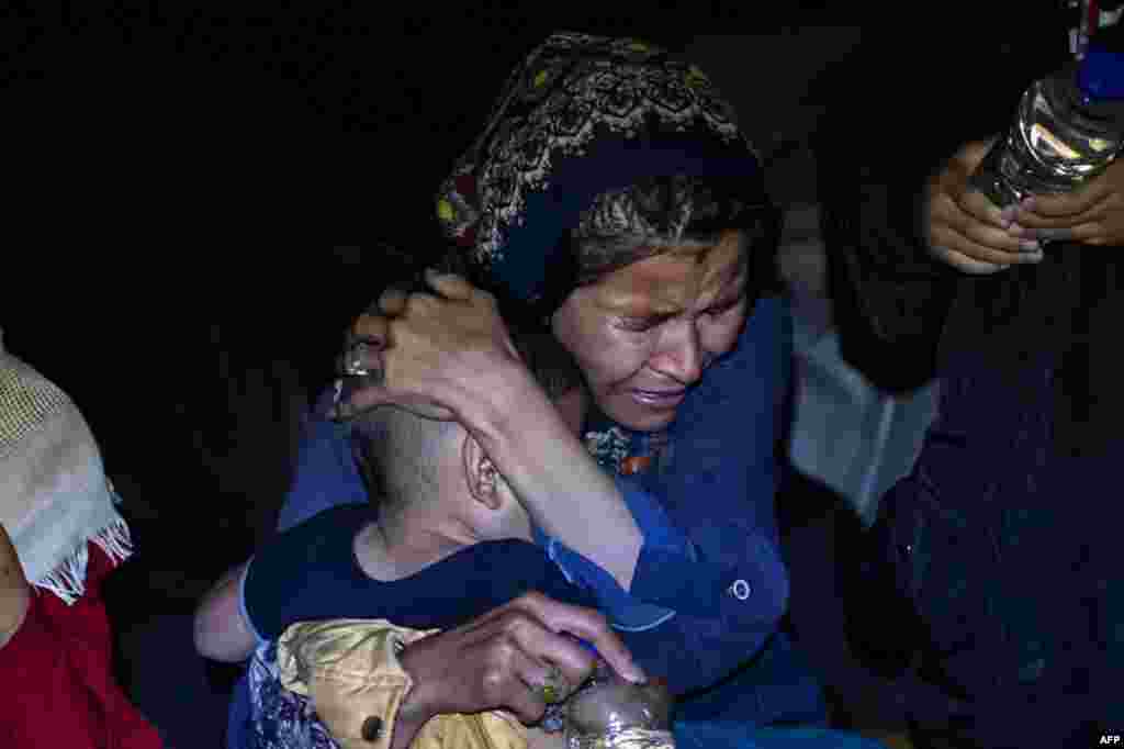 A woman migrant holds her baby, as she arrives at the port of Skala Sikamias, following a rescue operation by a Frontex patrol vessel, at the port of Skala Sikamias, on the island of Lesbos, Greece.