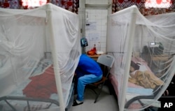 A relative visits a patient receiving treatment for dengue at University School Hospital in Tegucigalpa, Honduras, Aug. 20, 2019.