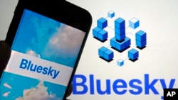 In this file photo, the app for Bluesky is shown on a mobile phone, left, and on a laptop screen on June 2, 2023, in New York. (AP Photo/Richard Drew, File)