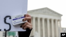 FILE - An abortion- rights activist holds a box of mifepristone pills as demonstrators from both anti-abortion and abortion-rights groups rally outside the Supreme Court in Washington, March 26, 2024. 