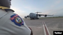 Yon polisye Ayisyen nan ayewopo Potoprens la nan moman avyon Aviyasyon Etazini ak Kanada rive pou livre asistans pou Polis Nasyonal Ayiti. (Foto: @USEmbassyHaiti Twitter)