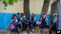 Student wait their turn to enter Lycee Marie Jeanne school on first day of school since the COVID-19 pandemic in Port-au-Prince, Haiti, Monday, Aug. 17, 2020. (AP Photo/Dieu Nalio Chery)