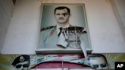 Một tấm áp phích rách nát có hình ảnh cố Tổng thống Syria Hafez al-Assad và con trai ông là Tổng thống bị lật đổ Bashar al-Assad, trên lối vào trại giam giữ an ninh khét tiếng có tên là Palestine Branch, tại Damascus, hôm 14/12/2024.