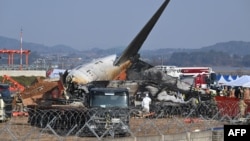 Lính cứu hỏa và nhân viên cứu hộ làm việc gần xác máy bay Boeing 737-800 của Jeju Air sau khi máy bay bị rơi và bốc cháy tại Sân bay quốc tế Muan, cách Seoul khoảng 288 km về phía tây nam, vào ngày 29/12/2024.