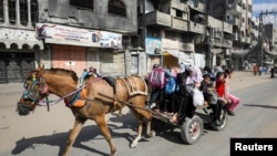 Người dân Palestine di tản trên xe ngựa khi di chuyển khỏi các khu vực ở phía bắc Dải Gaza sau lệnh sơ tán của Israel trong bối cảnh xung đột Israel-Hamas đang diễn ra tại Thành phố Gaza ngày 12/10/2024.