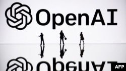 Ảnh chụp ngày 30/10/2023, tại Mulhouse, miền đông nước Pháp, cho thấy các tượng nhỏ bên cạnh một màn ảnh trình bày biểu tượng của OpenAI, một tổ chức trí tuệ nhân tạo của Mỹ.
