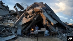 A man sells bread under the destruction of his bakery destroyed by the Israeli air and ground offensive in Jabaliya, Gaza Strip, Feb. 5, 2025.