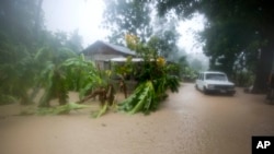 A vehicle sits next to a house, stranded in the flood waters caused by Hurricane Matthew, in Leogane, Haiti, Oct. 4, 2016. 