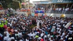 Families and friends gather around a memorial at the site of a high-voltage wire accident that left at least 16 people dead, during a vigil in Port-au-Prince, Haiti, Feb. 17, 2015. 