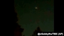 In this image taken from video, what appears to be a drone is seen above treetops in Flanders, New Jersey, Dec. 3, 2024. 