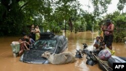 14 Eylül 2024 - Myanmar'ın Bago bölgesinde Yagi Tayfunu'yla gelen şiddetli yağışların ardından mahsur kalan bir grup bölge sakini kurtarma ekiplerini beklerken