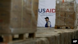 Foto Achiv: Yon neg pase bo kote bwat kes asistans imanite USAID nan yon depo nan Cucuta, Kolonbi, 21 Fevriye 2025.