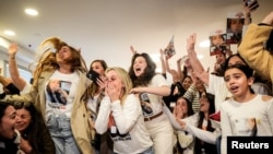 Family members and supporters of Israeli hostage Agam Berger react as they watch a broadcast of Berger during her release, in Holon, Israel, Jan. 30, 2025. 