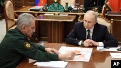 Tổng thống Nga Vladimir Putin (phải) lắng nghe Bộ trưởng Quốc phòng Nga Sergei Shoigu trong cuộc gặp tại Điện Kremlin ở Moscow, Nga, hôm 20/2.