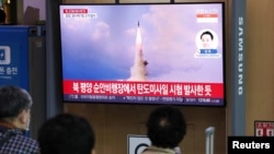 People watch a TV broadcasting a news report on North Korea's intercontinental ballistic missile (ICBM) test, in Seoul